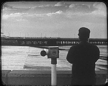 filmstill s/w Mann von hinten am Strand