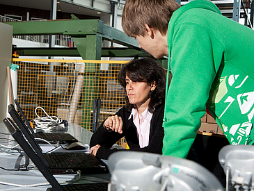 Zwei Personen arbeiten an einem Laptop.