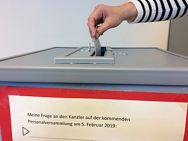 Wahlurne mit Hand, die einen Zettel hineinwirft Wahlurne mit Hand, die einen Zettel hineinwirft