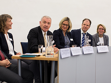 Gruppe von Personen an einem Podium