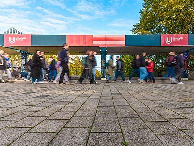 People blurred by their movement, walking across the boulevard