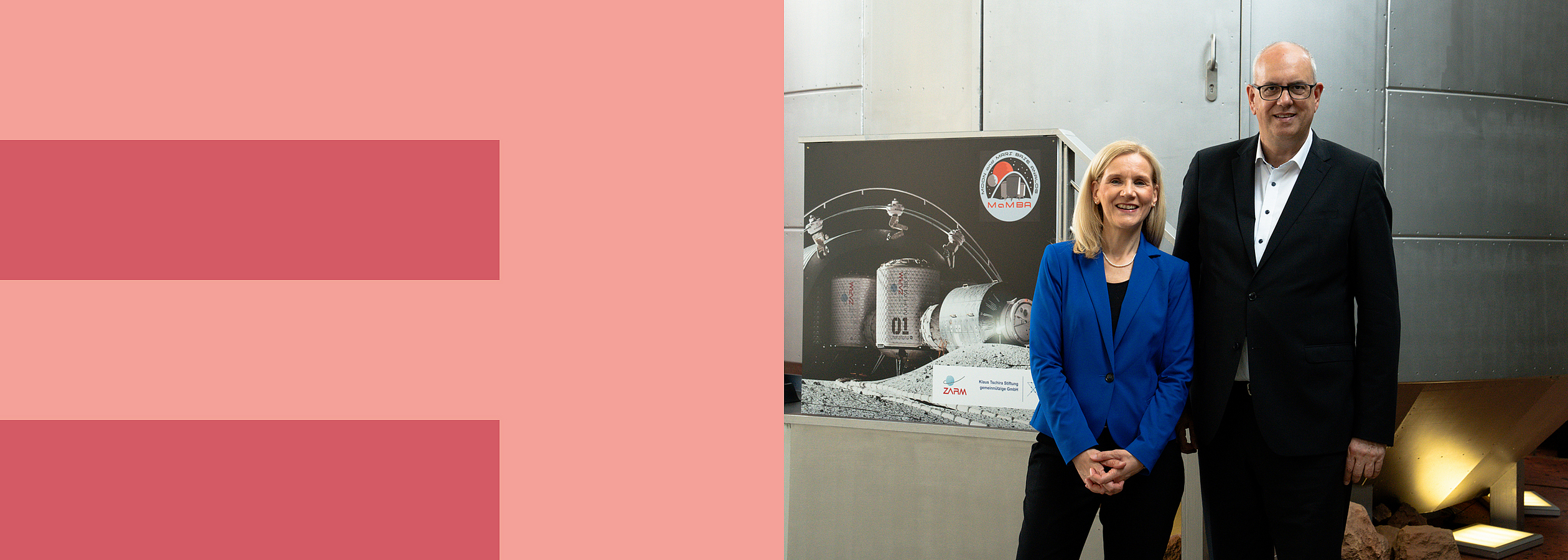 Jutta Günther and Andreas Bovenschulte stand in front of a cylindrical, walk-in capsule at ZARM