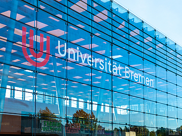 Glashalle mit dem Universitätslogo