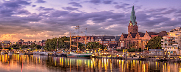 Schlachte The Schlachte in Bremen lies in the evening light, the Weser can be seen in the foreground, the lights of the buildings shine in the background