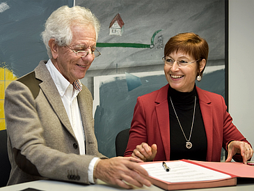 Mann und Frau bei der Unterzeichnung von Dokumenten