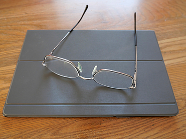 Tablet mit Brille Holzhintergrund Tablet mit Brille