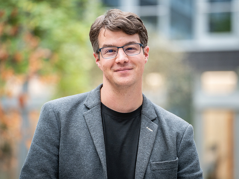 Ein Mann lächelt in die Kamera.